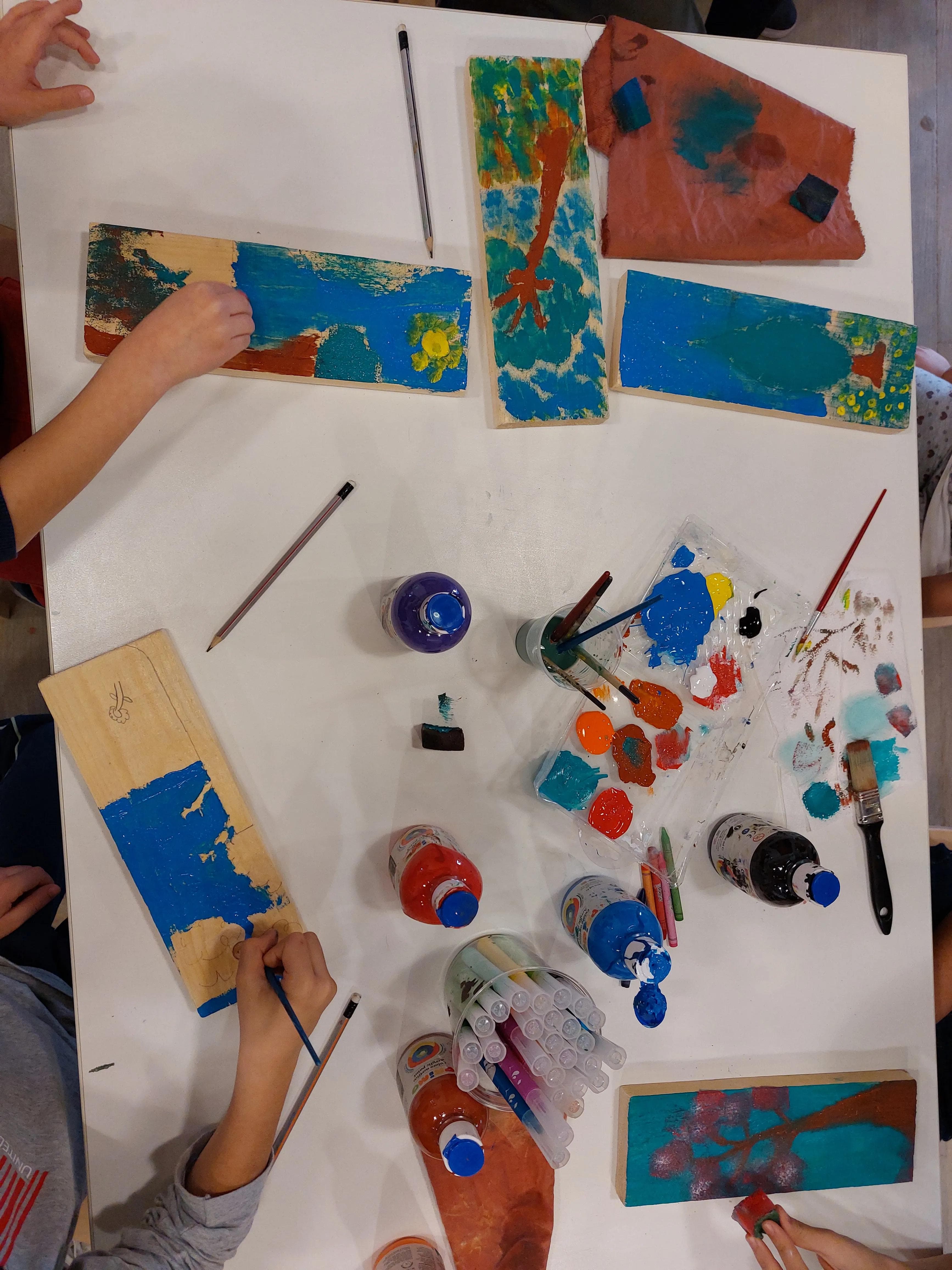 paintings and hands on a desk