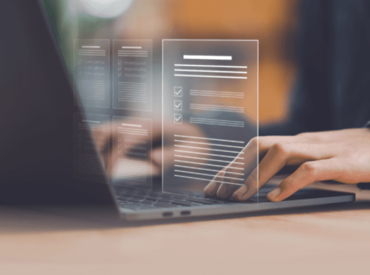 Hands typing on a laptop with a hologram hovering it