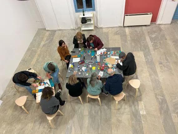 group of people painting while sitting in a desk
